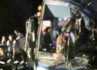 Rescue workers struggle to free injured passengers from the badly damaged tour bus.